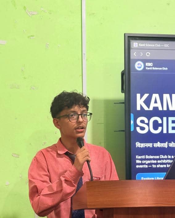 Dipin speaking into a microphone at a Kanti Science Club event